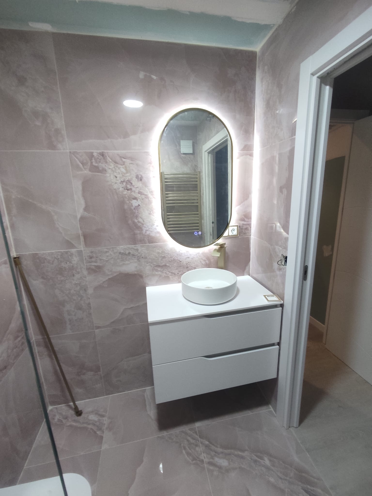 Baño de mármol con espejo retroiluminado - HG Reformas